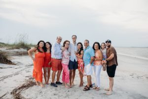 An extended family on the beach wearing bright colors
